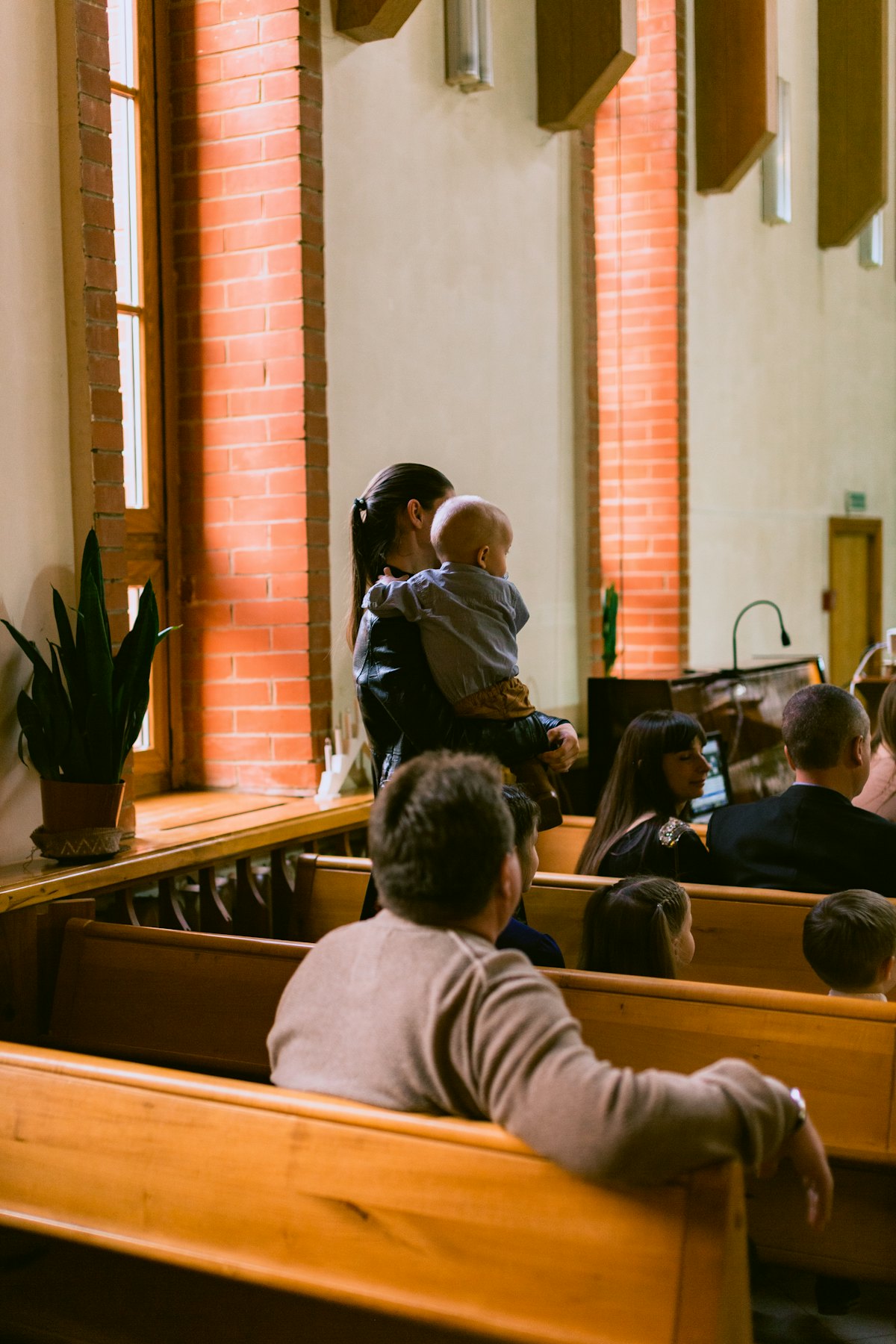 A parent holding a young child in a small chapel